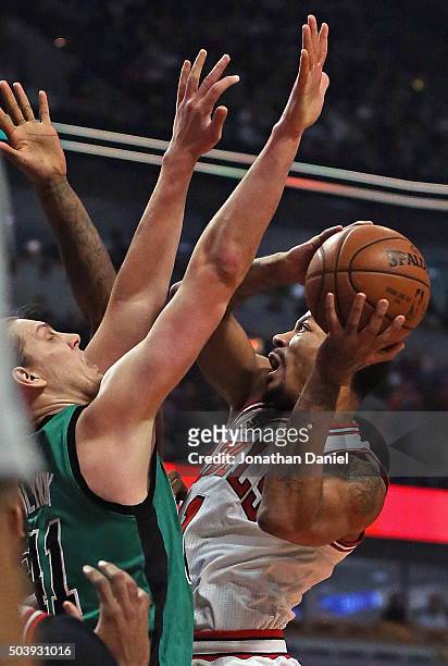 Derrick Rose of the Chicago Bulls shoots against Kelly Olynyk of the Boston Celtics at the United Center on January 7, 2016 in Chicago, Illinois....