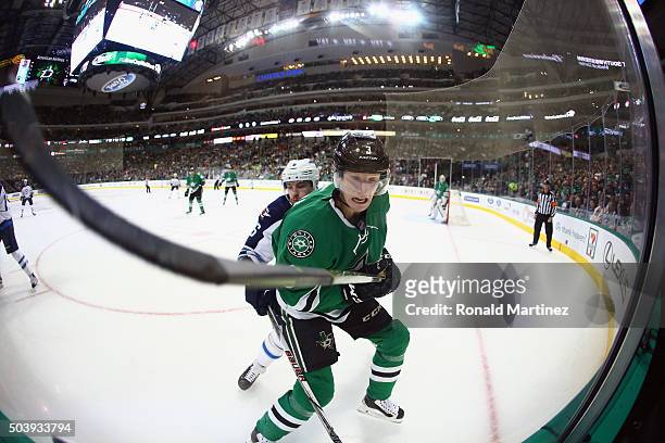 John Klingberg of the Dallas Stars is checked by Alexander Burmistrov of the Winnipeg Jets in the second period at American Airlines Center on...