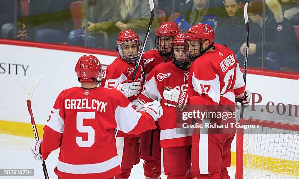 Danny O'Regan of the Boston University Terriers celebrates one of his two goals against the Harvard Crimson with teammates Matt Grzelcyk, Jakob...