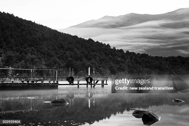 black and white morning mist and reflection on lake rotoiti, nelson lakes national park, new zealand - nelson lakes national park stock pictures, royalty-free photos & images