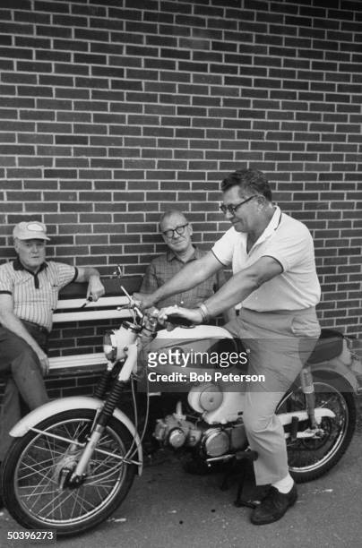 Redskins Coach, Vince Lombardi, sitting on a Honda motorcycle.