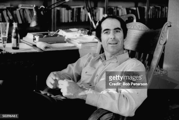 Author, Philip Roth, drinking a glass of beer as he pauses during work on manuscript.