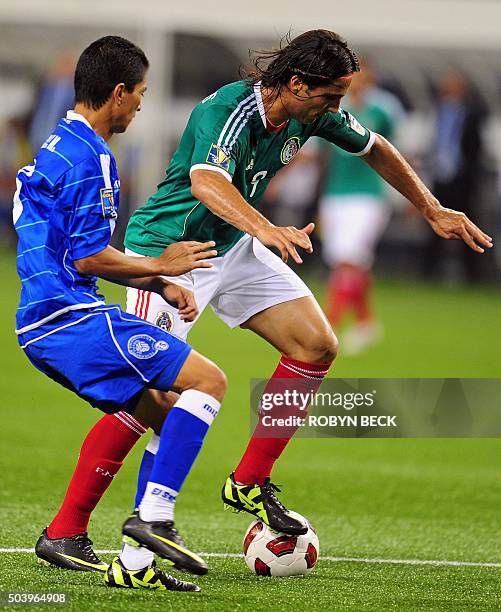 Mexico's Aldo De Nigris drives past El Salvador's Marvin Gonzales during the 2011 CONCACAF Gold Cup first round group match between El Salvador and...