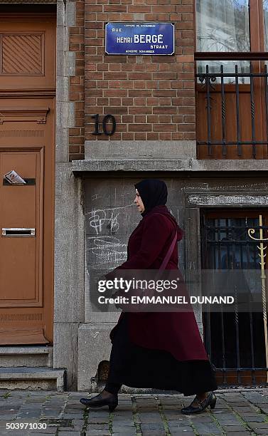 Woman walks past a sign indicating Rue Henri Berge in the Brussels district of Schaerbeek, on January 8, 2016 in Brussels. Belgian police have found...