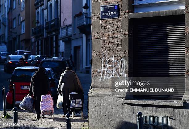 Picture taken on January 8, 2016 in the Brussels district of Schaerbeek shows people walking in the Rue Henri Berge. Belgian police have found three...