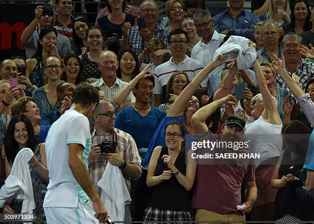 Fans catch the towel of Roger Federer of Switzerland after his quarter-final match against Bulgaria's Grigor Dimitrov during their men's singles on...