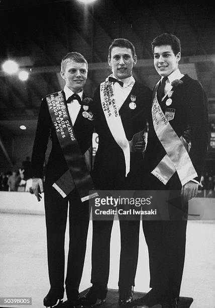 Skaters Donald Knight , Alain Calmat , and Scott Ethan Allen posing with awards at the World Figure Skating Championships.