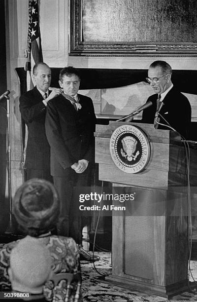 Painter Andrew Wyeth , receiving freedom medal at White House ceremony, from President Lyndon B. Johnson , as Angier Biddle Duke observes.