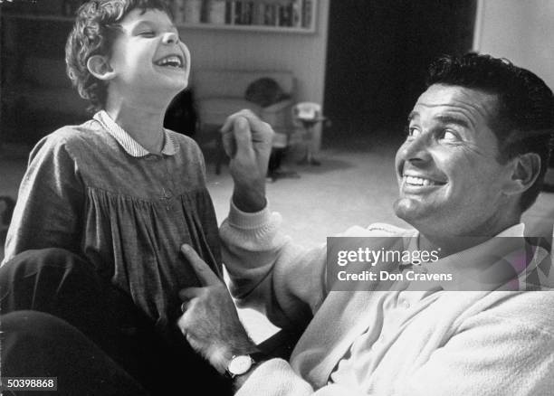 Actor, James Garner, relaxing with his daughter at home.