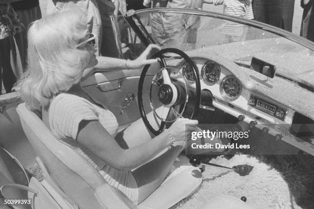 Singer Juli Reding driving in her car through a crowded street of fans.