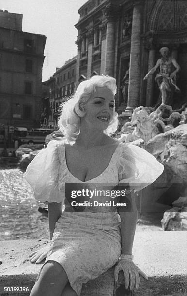 Singer Juli Reding sitting in front of a water fountain during her visit.