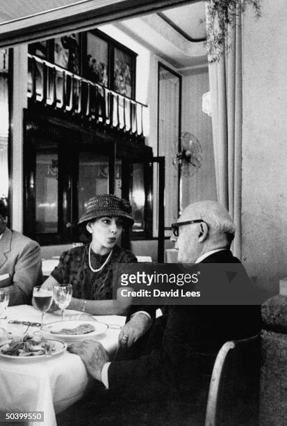 Impresario Sol Hurok sitting with opera singer Maria Callas at a dinner.