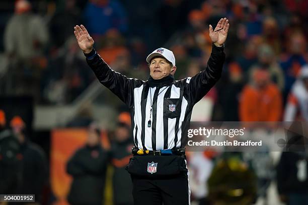 Referee Ed Hochuli signals a time out during a game between the Denver Broncos and the Cincinnati Bengals at Sports Authority Field at Mile High on...