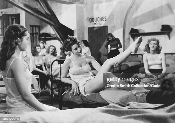 Au Royaume Des Cieux , movie still of girls sitting on beds in a dormatory, one girl showing off her leg, from the film noir movie by director Julien...