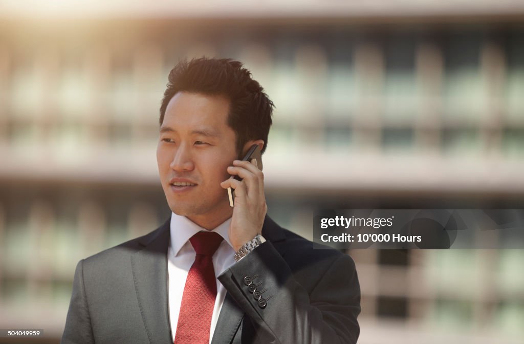 Businessman talking on a mobile phone in the city