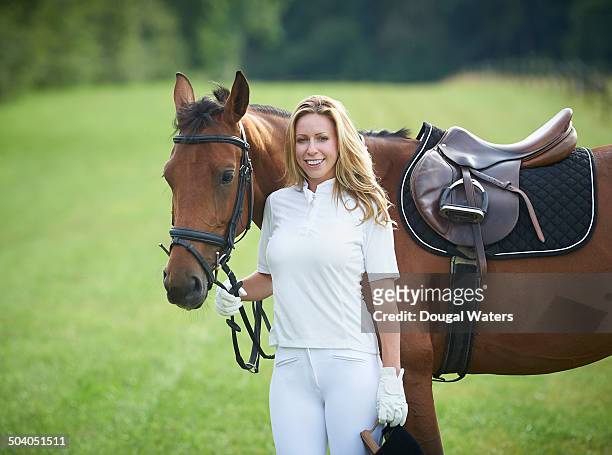 female jockey and horse in field. - female jockey stock pictures, royalty-free photos & images