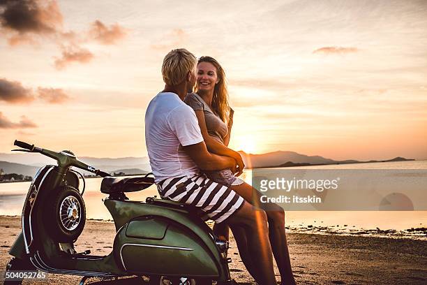 coppia sulla spiaggia con scooter vintage - mare moto foto e immagini stock