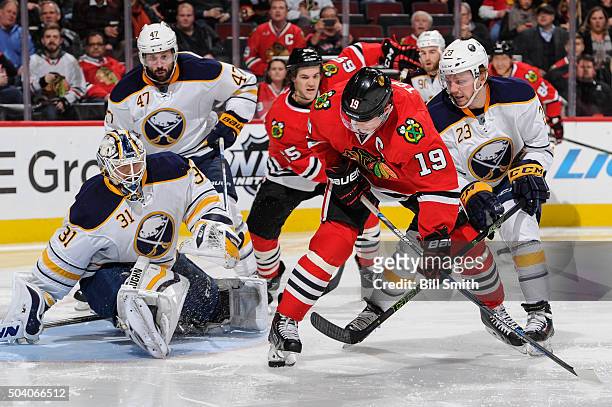 Jonathan Toews of the Chicago Blackhawks and Sam Reinhart of the Buffalo Sabres battle for the puck in front of goalie Chad Johnson in the second...