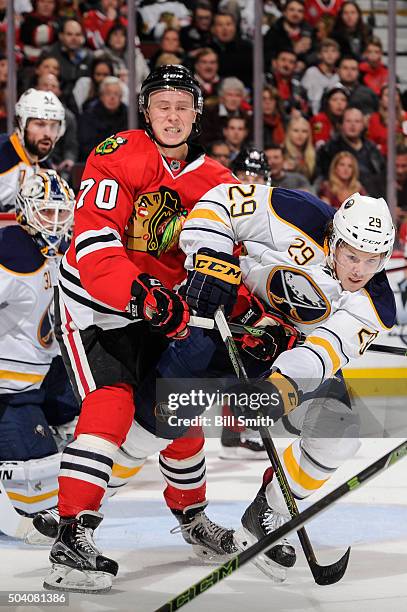 Dennis Rasmussen of the Chicago Blackhawks and Jake McCabe of the Buffalo Sabres get physical in the second period of the NHL game at the United...