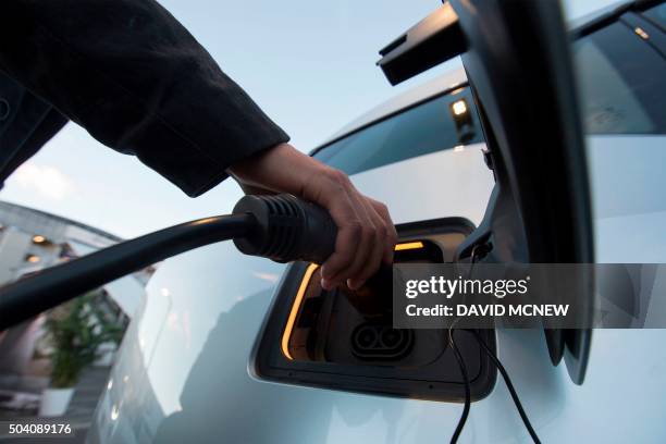 I3 electric car is plugged into a charging station at the CES 2016 Consumer Electronics Show on January 8, 2016 in Las Vegas, Nevada. AFP PHOTO/...