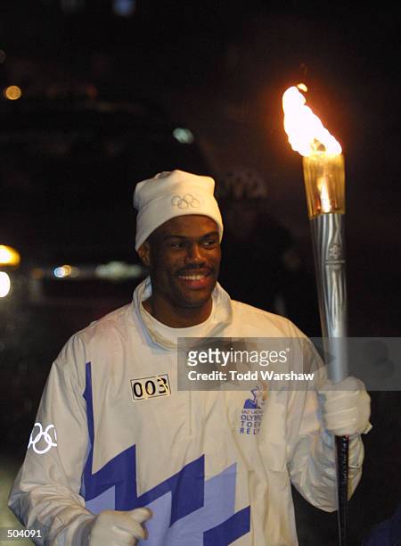 Torchbearer David Robinson of the NBA's San Antonio Spurs carries the Olympic Flame during the 2002 Salt Lake Olympic Torch Relay in San Antonio,...