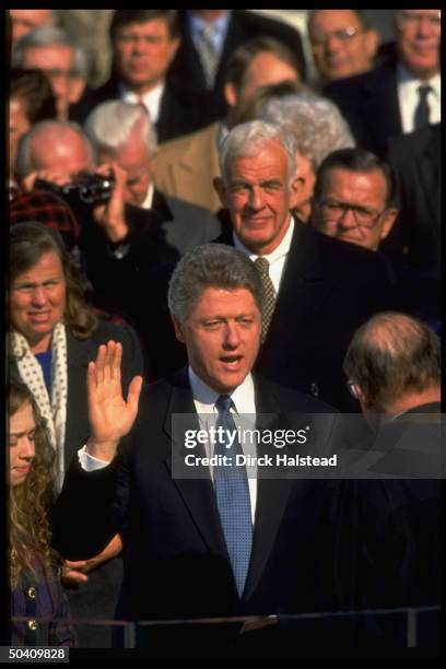 Pres. Bill Clinton raising hand, taking oath of office in his Inaugural Day swear-in , Chief Justice William Rehnquist officiating.