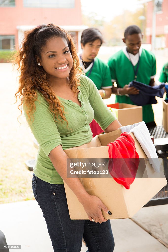 Group of college student volunteers collect clothing donations. Charity.