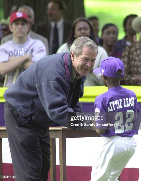 President George W. Bush giving a gift to unident. Little league team member of Capitol City Rockies after tee ball game on South Lawn of White House.