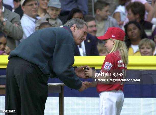President George W. Bush handing an autographed baseball to Little League Memphis Red Sox team member Kate McDough after tee ball game on South Lawn...