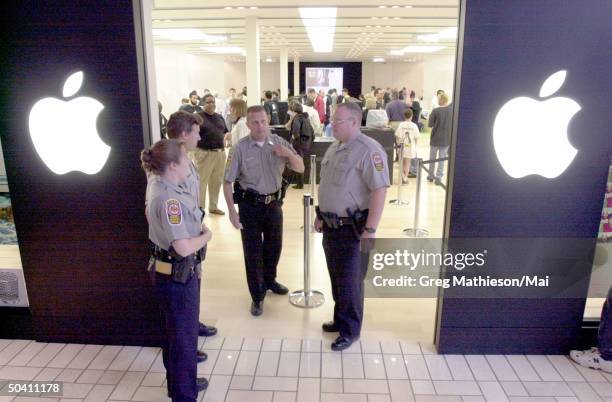 Security guards at entrance of Apple retail store, which Apple opened to provide direct sales to consumers of Apple and associated products.
