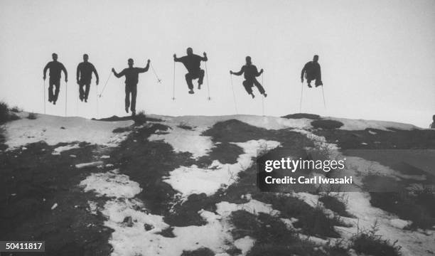 Ski students at the University of Denver leaping off a hill.