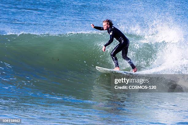 man surfing the wave at noordhoek beach - noordhoek beach stock pictures, royalty-free photos & images