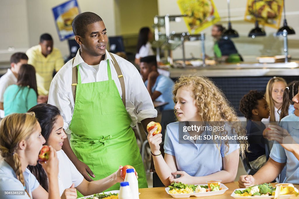 Students enjoy apples and chat during school lunch break