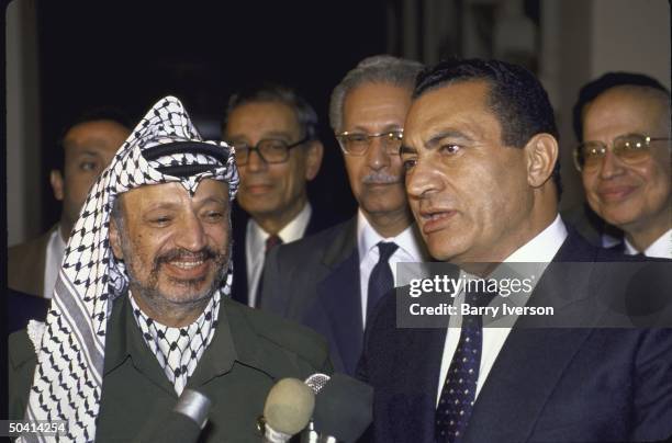 Egyptian Pres. Husni Mubarak standing with Palestine Liberation Organization leader Yasser Arafat .