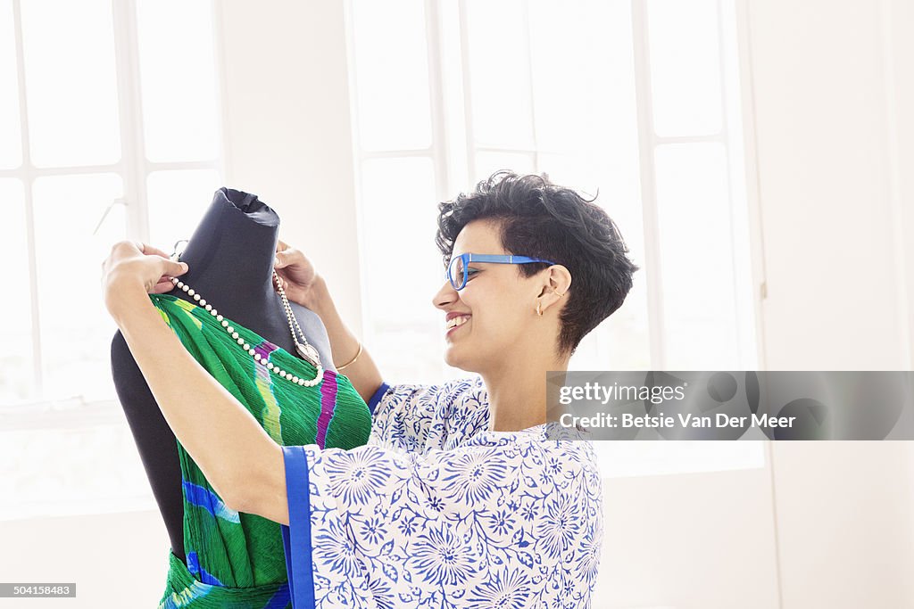 Fashion designer choosing jewelery with dress.