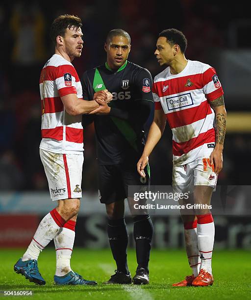 Glen Johnson of Stoke City shakes hands with Luke McCullough and Nathan Tyson of Doncaster Rovers after the Emirates FA Cup Third Round match between...