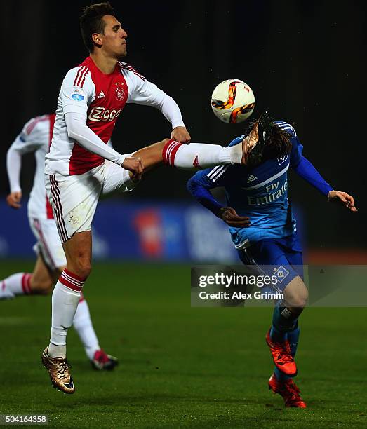 Gotoku Sakai of Hamburg is challenged by Arkadiusz Milik of Ajax during a friendly match between Hamburger SV and Ajax Amsterdam at Gloria Sports...