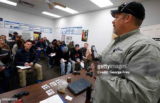 Gun instructor Mike Stilwell, demonstrates an semi automatic hand gun as as he teaches a packed class to obtain the Utah concealed gun carry permit,...