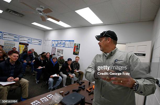 Gun instructor Mike Stilwell, demonstrates an revolver as as he teaches a packed class to obtain the Utah concealed gun carry permit, at Range Master...