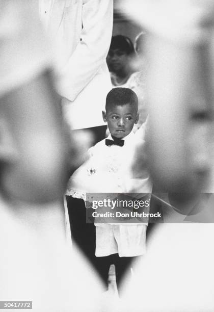 Little boy as ring-bearer at African American wedding.