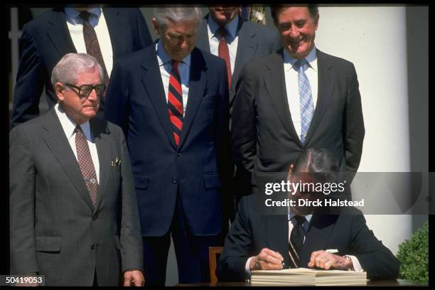 Pres. Ronald Reagan signing Catastrophic Care bill, w. Health Secy. Otis Bowen & Sen. Lloyd Bentsen .