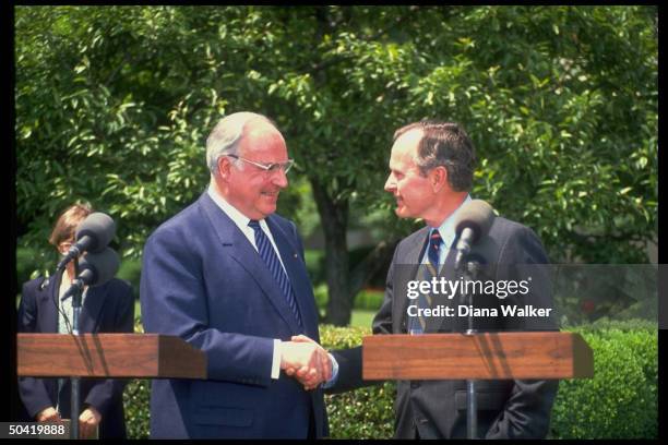 Pres. Bush w. W. German Chancellor Helmut Kohl, shaking hands during departure ceremony on WH grounds.