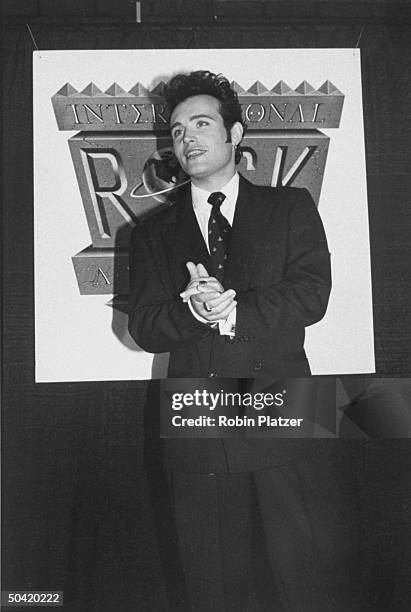 Rock star Adam Ant in a double-breasted suit, standing in front of International Rock Awards sign.