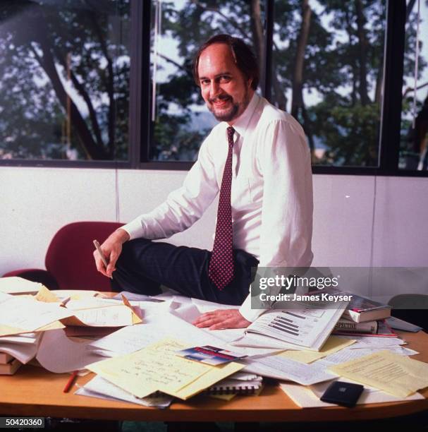 Sr. VP at polling and market research firm Yankelovich Clancy Shulman, Hal Quinley, sitting on desk w. Papers on it.