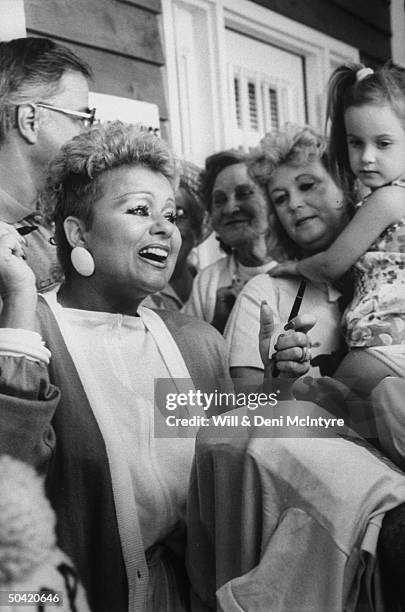 Wife of disgraced PTL evangelist Jim Bakker, Tammy Faye Bakker, autographing t-shirts of supporters, outside the HQ of the Covenant Ministries, the...