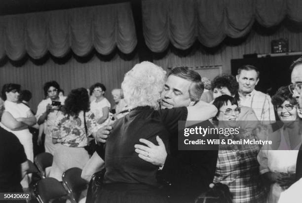 Disgraced PTL evangelist Jim Bakker hugging supporter after PTL Camp Meeting show.