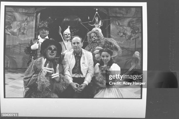 Portrait of the cast of the stage version of the Wizard of Oz surrounding producer Michel Grilikhes; Bart Williams, the Wizard; Joe McDonough, the...