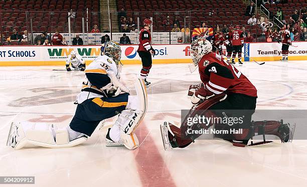 Goaltenders Pekka Rinne of the Nashville Predators and Anders Lindback of the Arizona Coyotes talk at center ice before the start of an NHL game at...