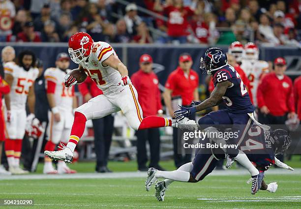 Travis Kelce of the Kansas City Chiefs carries the ball against Kareem Jackson and Johnathan Joseph of the Houston Texans in the fourth quarter...