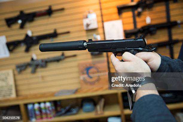 Customer tries out a Remington 1911 equipped with a silencer at Blue Ridge Arsenal in Chantilly, Va., USA on January 9, 2015.